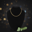 14ct Gold 18 45cm 4mm 31 Figaro Link Chain displayed on a black bust against a sparkling background.