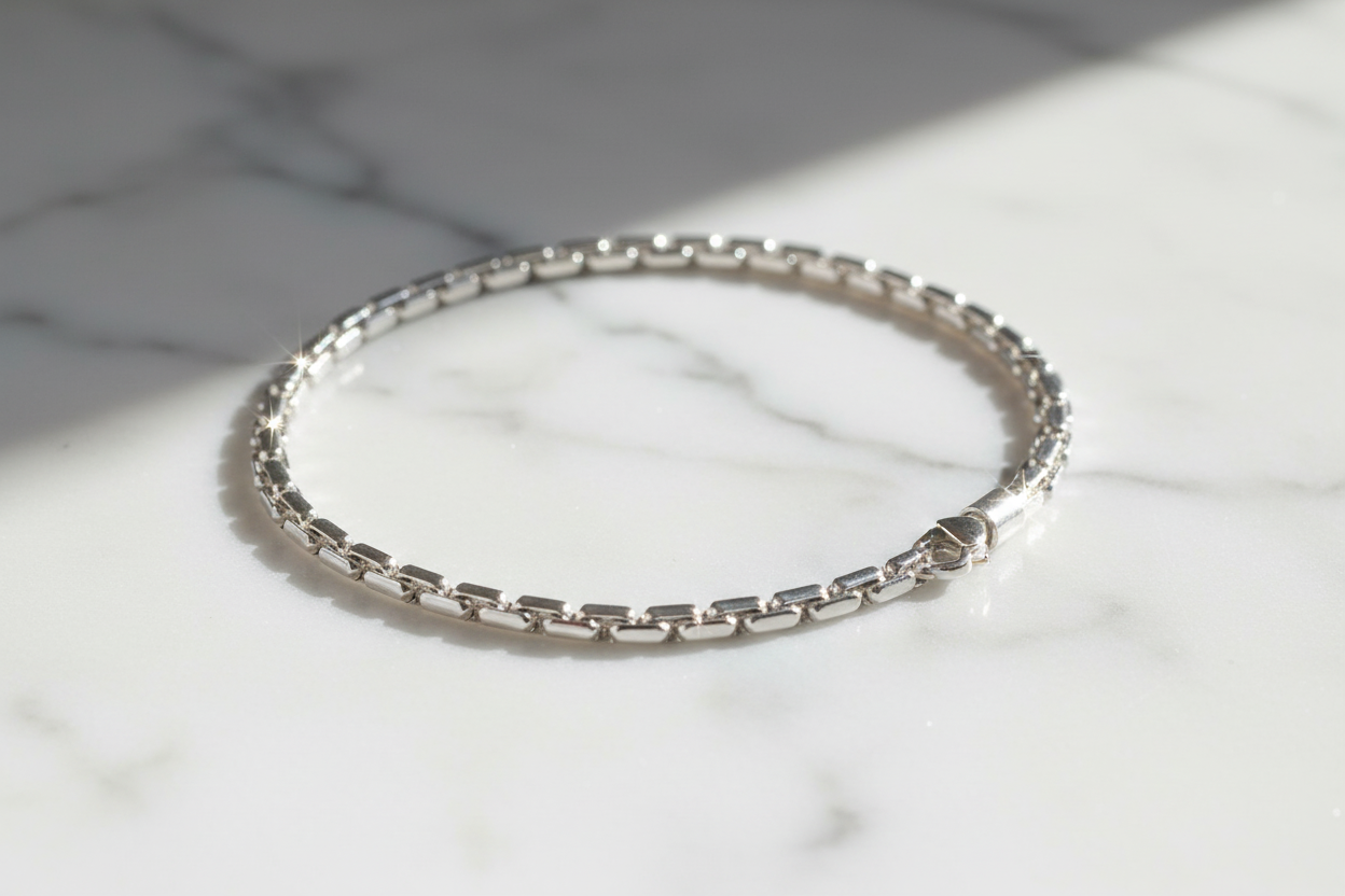 19cm sterling silver figaro chain bracelet on natural stone background with sparkle