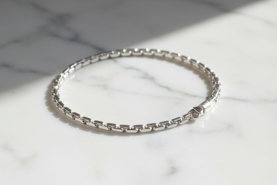 19cm sterling silver figaro chain bracelet on natural stone background with sparkle