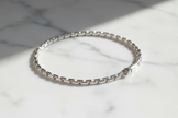 19cm sterling silver figaro chain bracelet on natural stone background with sparkle