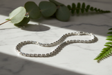 19cm sterling silver figaro chain bracelet with enhanced sparkle and greenery on natural stone