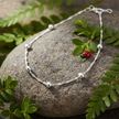 Anklet on rock with greenery, ladybug and sparkle