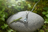 Aquamarine pendant on rock with small lizard