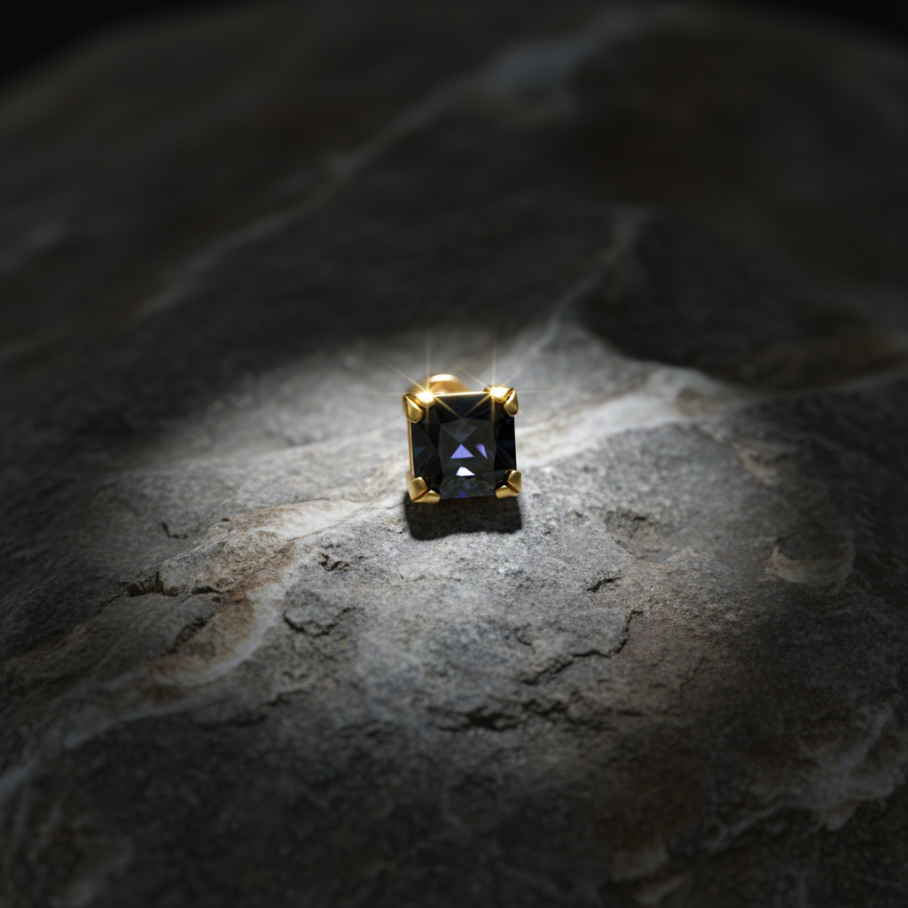 Black gemstone stud on rock with sparkle