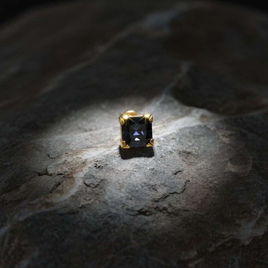 Black gemstone stud on rock with sparkle