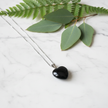 Black Obsidian Necklace on White Marble with Greenery
