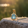 Blue topaz pendant front view on rock