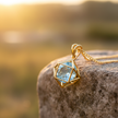 Blue topaz pendant on rock with natural sunlight