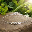 Clear sharp infinity bracelet with sunlight on rock