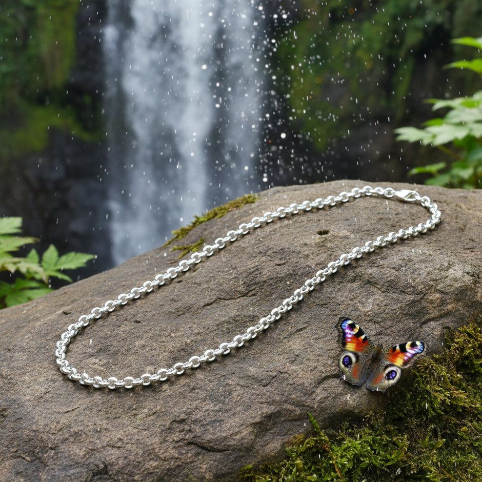 Complete belcher chain laid on rock with butterfly and waterfall
