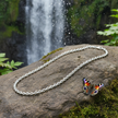 Complete belcher chain laid on rock with butterfly and waterfall