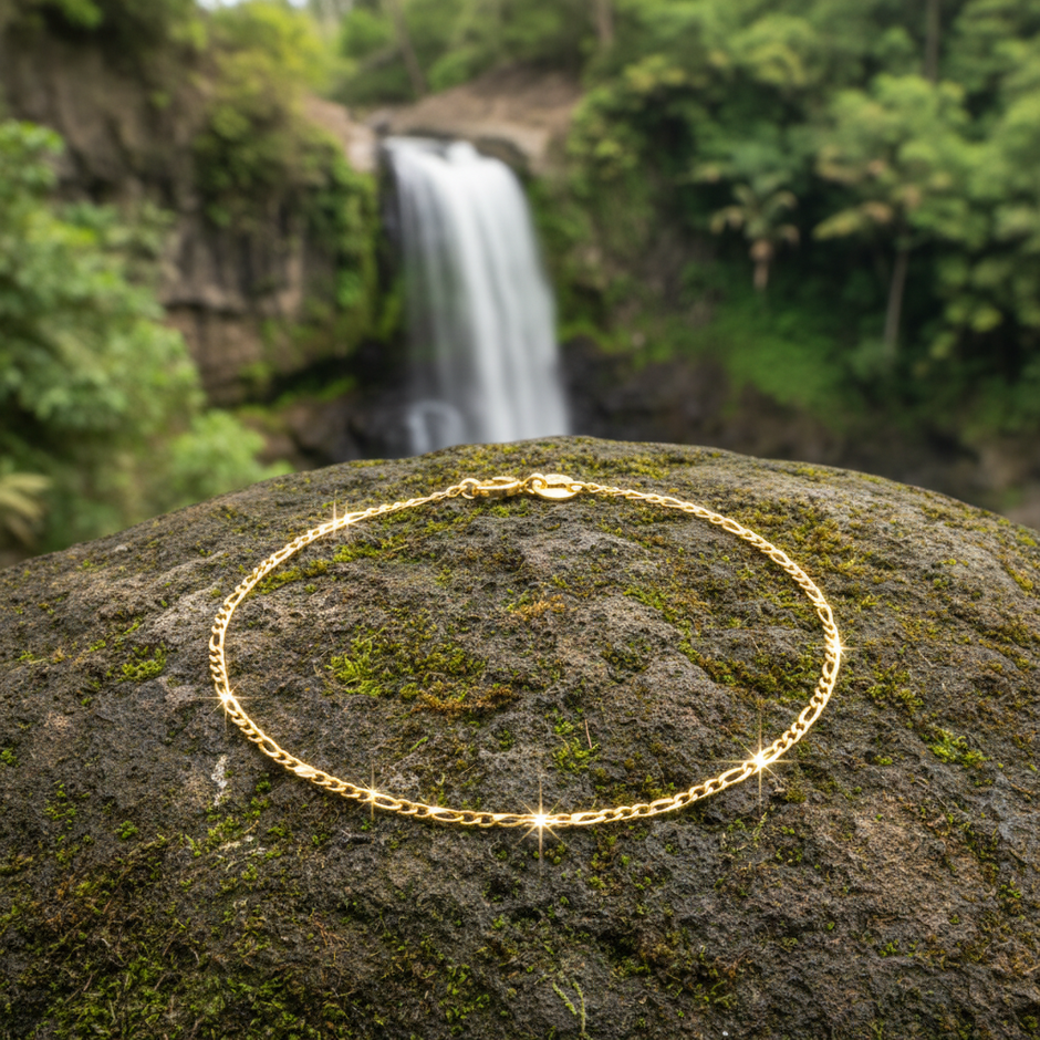 Complete gold bracelet with single clasp on rock with waterfall