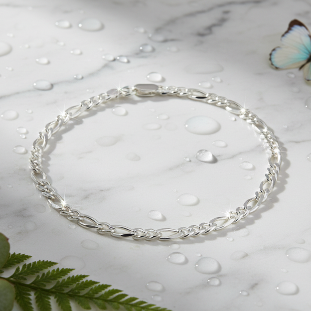 Complete Italian sterling silver figaro bracelet on marble with water drops, butterfly and greenery