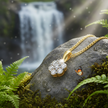 Diamond pendant on rock near waterfall with butterfly