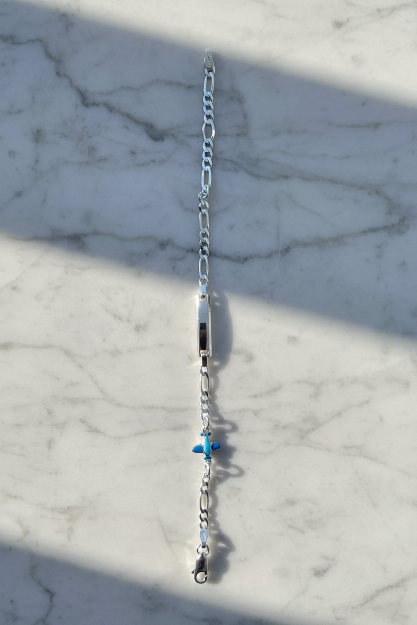 Enhanced sterling silver figaro chain bracelet on natural stone background