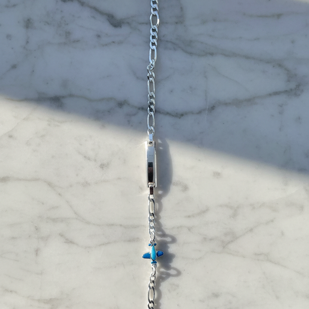 Enhanced sterling silver figaro chain bracelet on natural stone background