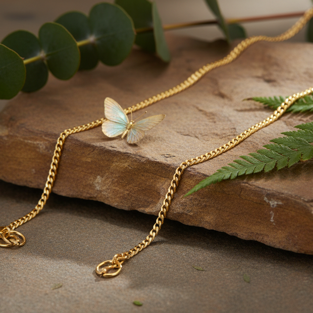 Gold chain on rock with butterfly and greenery