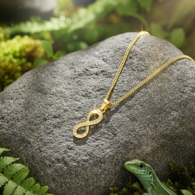 Gold infinity necklace with lizard peeking from behind rock