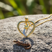Heart and star pendant face-forward view on rock
