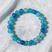 Natural 8mm Blue Agate crystal stone bracelet on white velvet with silver dust