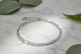 Italian 925 sterling silver curb chain bracelet with overhead sunlight sparkle, water mist and greenery