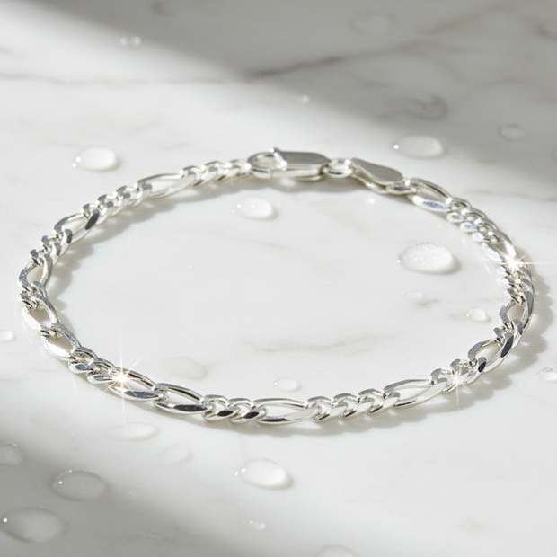 Italian sterling silver figaro chain bracelet on marble with water drops