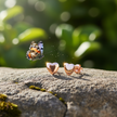 Rose gold heart earrings with butterfly landing on rock
