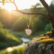 Rose gold heart pendant hanging from branch with sunlight
