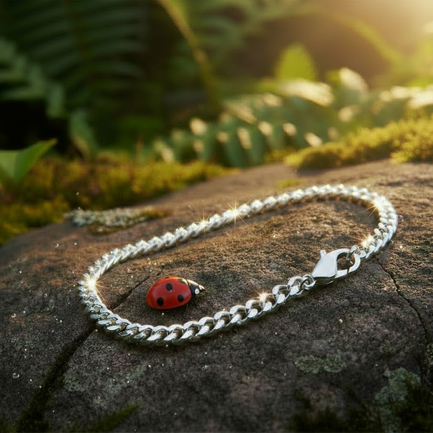 Silver bracelet with dew drops and ladybug on rock