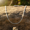 Silver curb chain with sparkle on rock
