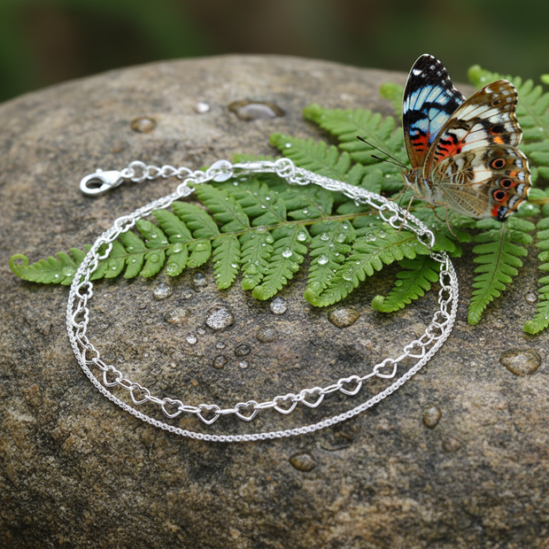 Silver double-strand anklet with butterfly, greenery, and dew drops