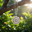 Silver sunburst pendant hanging from branch with dew