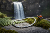 Sterling silver figaro bracelet near waterfall with greenery and butterfly