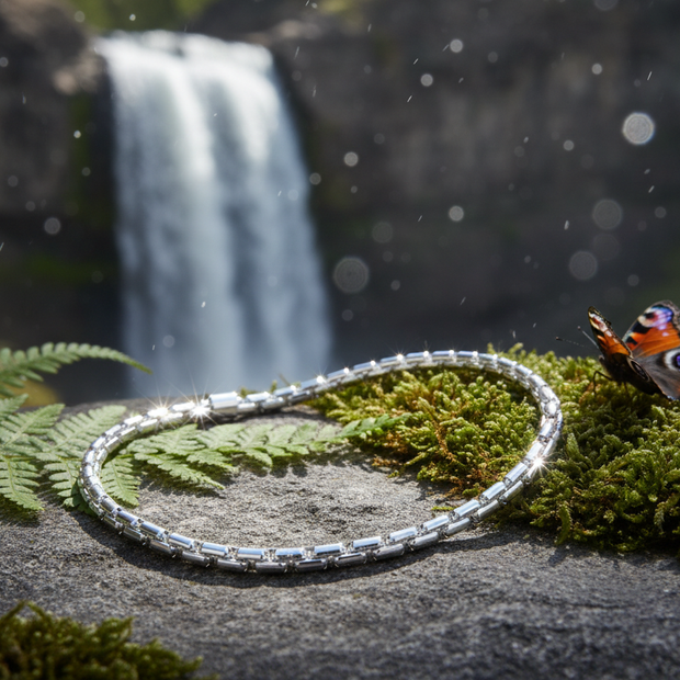Sterling silver figaro bracelet near waterfall with greenery and butterfly