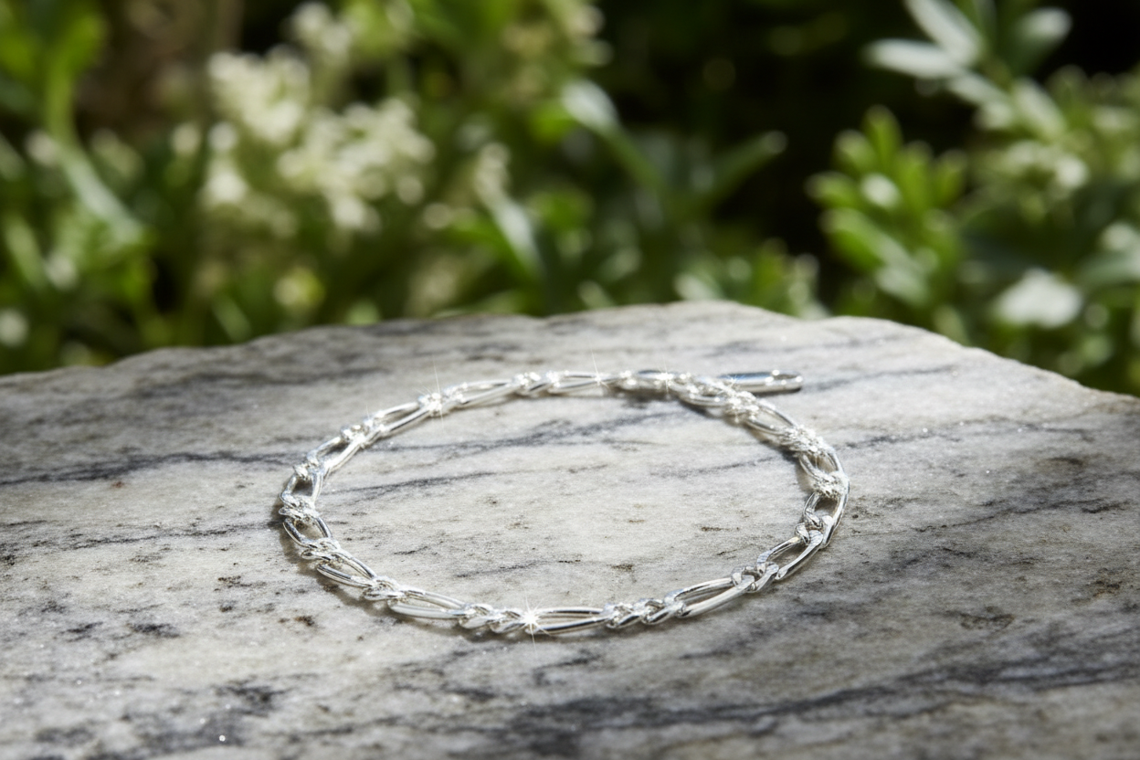 Sterling silver figaro chain bracelet on marble rock in natural environment