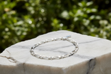 Sterling silver figaro chain bracelet on marble rock in natural setting