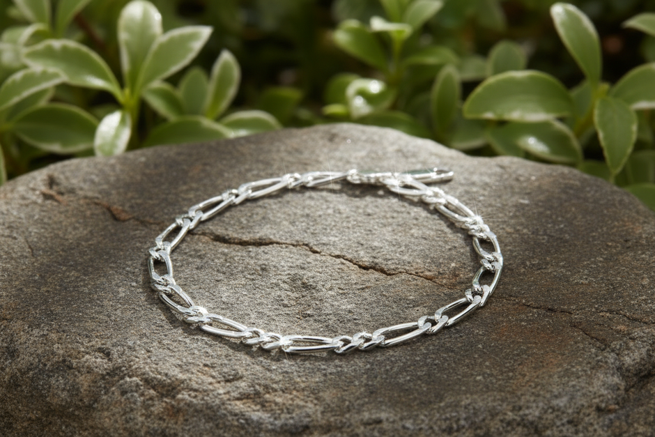 Sterling silver figaro chain bracelet on natural rock with greenery