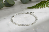 Sterling silver figaro chain bracelet with direct sunlight and intense sparkle