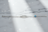 Sterling silver figaro chain bracelet with dramatic sparkle on marble background