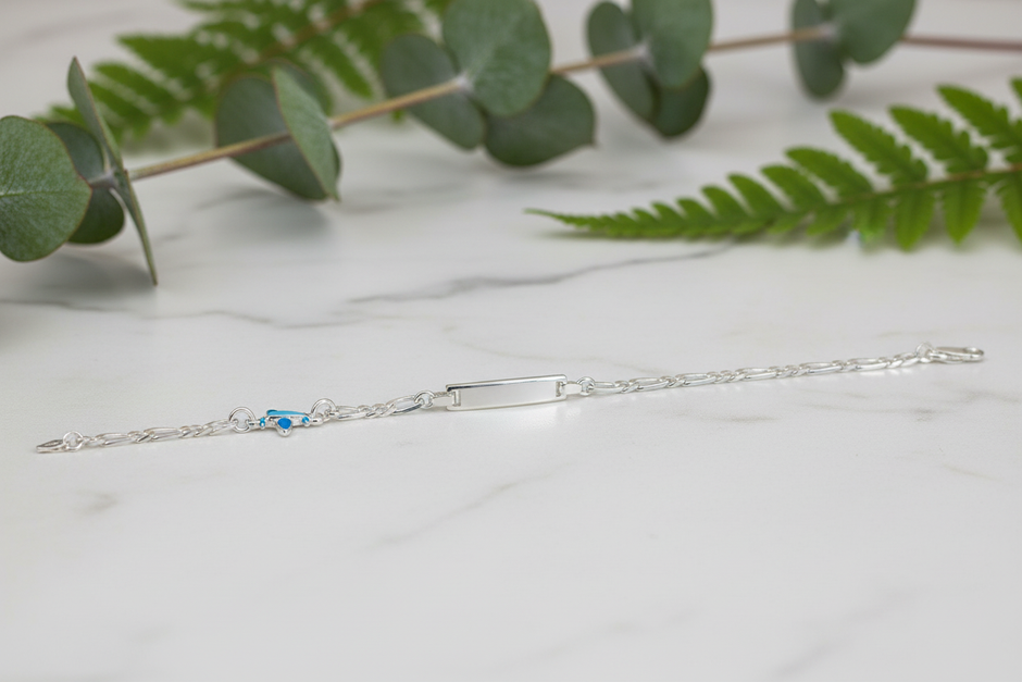 Sterling silver figaro chain bracelet with greenery on marble background